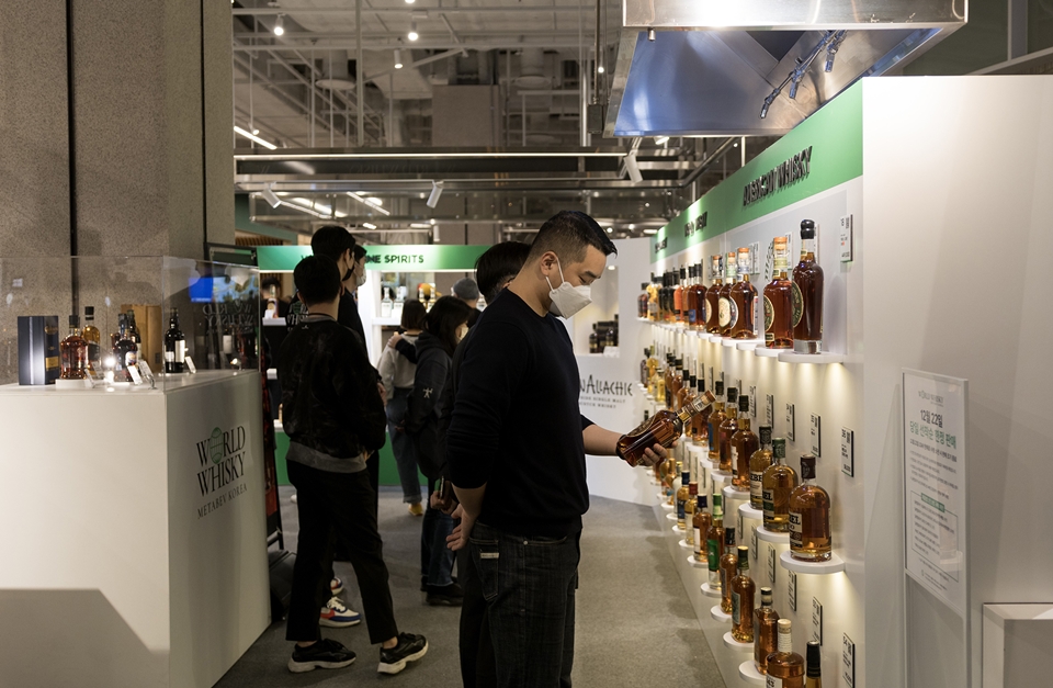 월드 위스키 공항 팝업에서 구매를 위해 제품을 살펴보는 소비자 (사진=메타베브코리아)