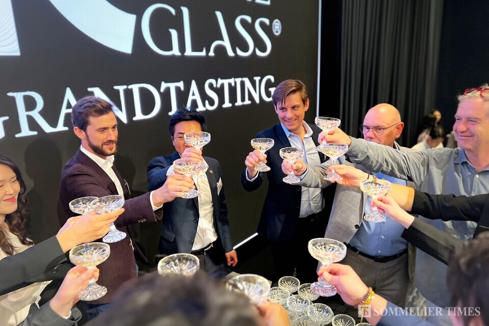 와이넬의 김세훈 총괄이사와 와이너리 관계자, 참여작가들이 함께 샴페인 축배를 들고있다.