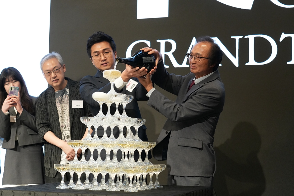 샴페인 타워 이벤트를 진행하는 와이넬의 김원오 대표(우)와 김세훈 총괄이사(좌)